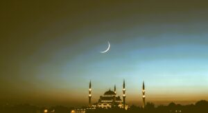 Crescent moon over mosque during Ramadan night, peaceful and reflective atmosphere