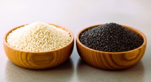 White and black sesame seeds in wooden bowls