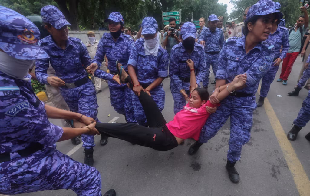 India's Cockroach Party Explained:Security personnel detain protesters in New Delhi.