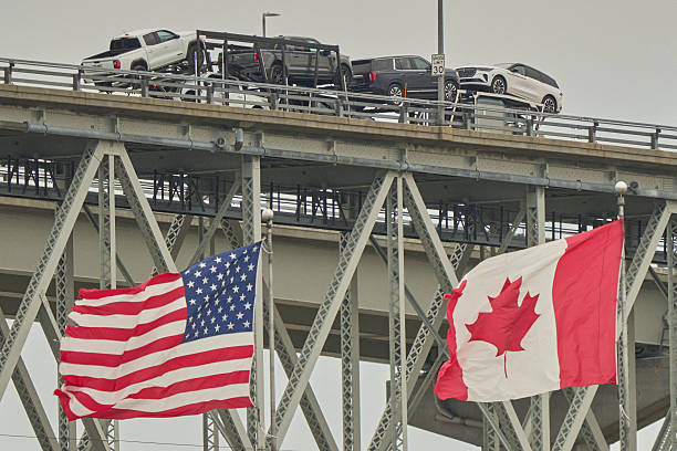 TOPSHOT - A truck with vehicles crosses the Blue Water Bridge border crossing into the United States from Sarnia, Ontario,
